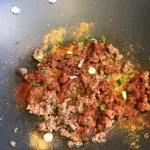 Adding spices and frying the mixture of meat and vegetables in Boston, MA