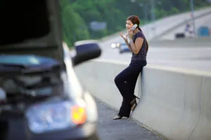 Woman on phone with wrecked car